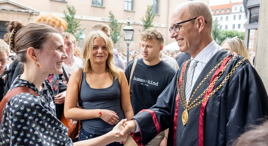 Rektor der giver hånd til de nye studerende til immatrikulationen