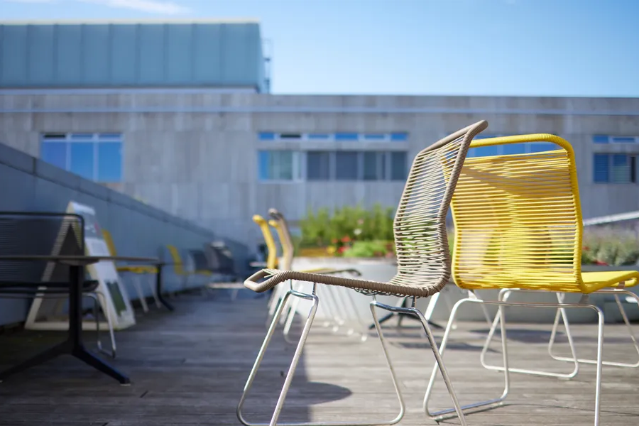 To gule stole står på en tagterrasse på Søndre Campus. I baggrunden ses en bygning og den blå himmel